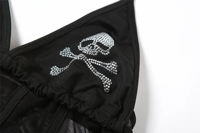Close-up of a sparkling skull-and-crossbones motif on one black triangular cup, with the gathered lower seam visible.