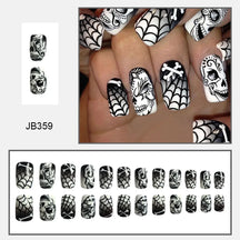 Black-and-white square nail design with decorated skulls, spiderwebs and crossed bone motifs, shown worn and arranged by size.