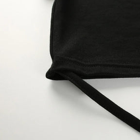 Close view of a long black waist tie attached to the lower corner of the cropped top.