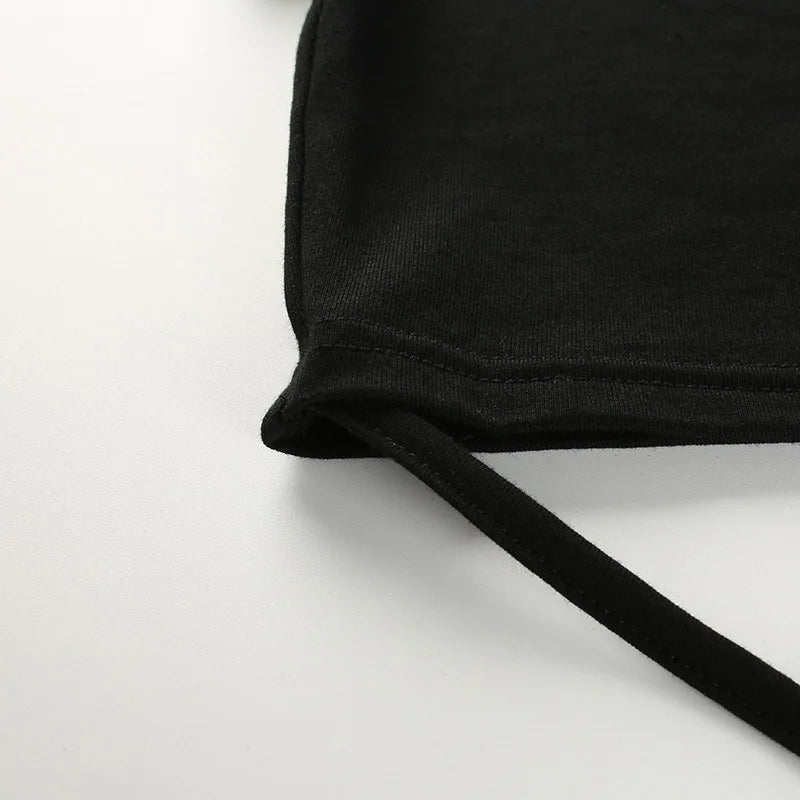 Close view of a long black waist tie attached to the lower corner of the cropped top.