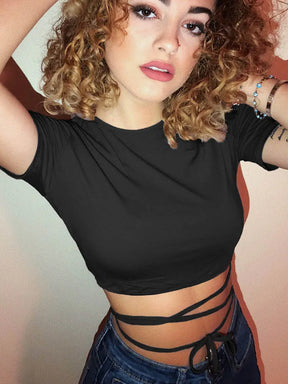 Model wearing the plain black short sleeve crop top and jeans in a portrait photograph, with long ties wrapped around the waist.