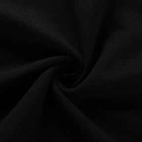 Close-up of the black crop top fabric gathered into folds, showing its fine surface texture.