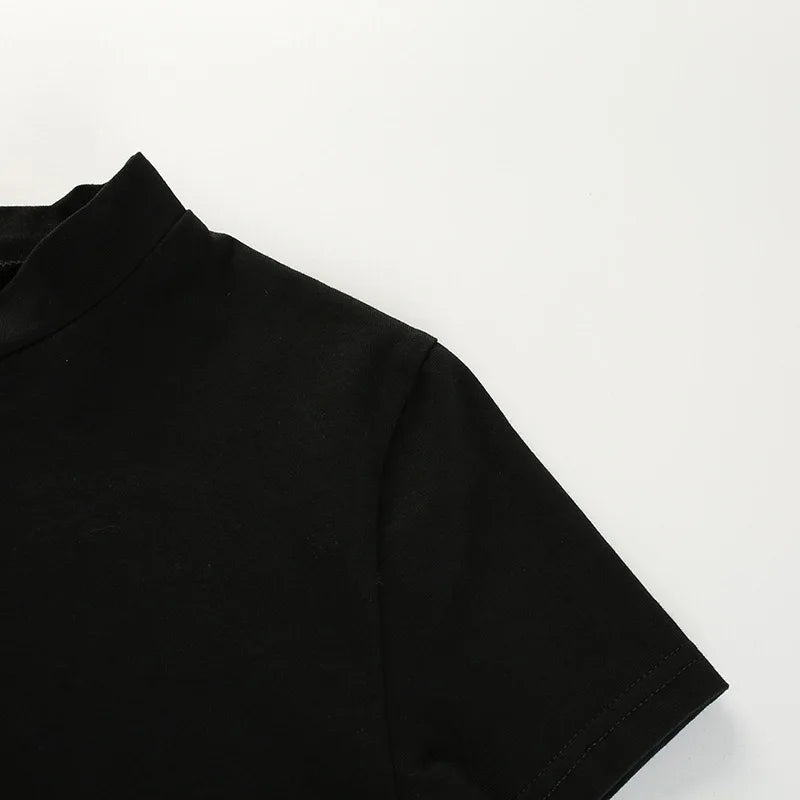Black crop top laid flat to show the short sleeve shape and shoulder seam.