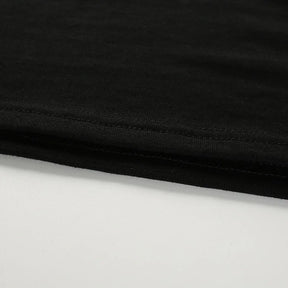 Close-up of the black top's straight cropped hem and parallel stitching.