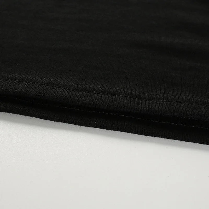Close-up of the black top's straight cropped hem and parallel stitching.