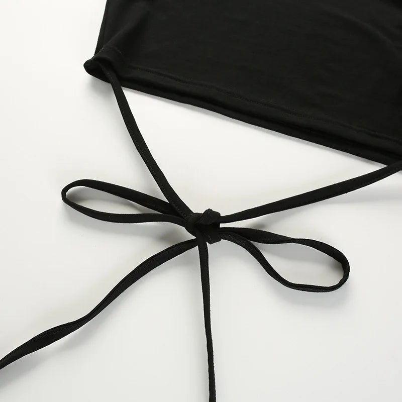 Long black waist ties arranged in a bow below the cropped hem on a white surface.