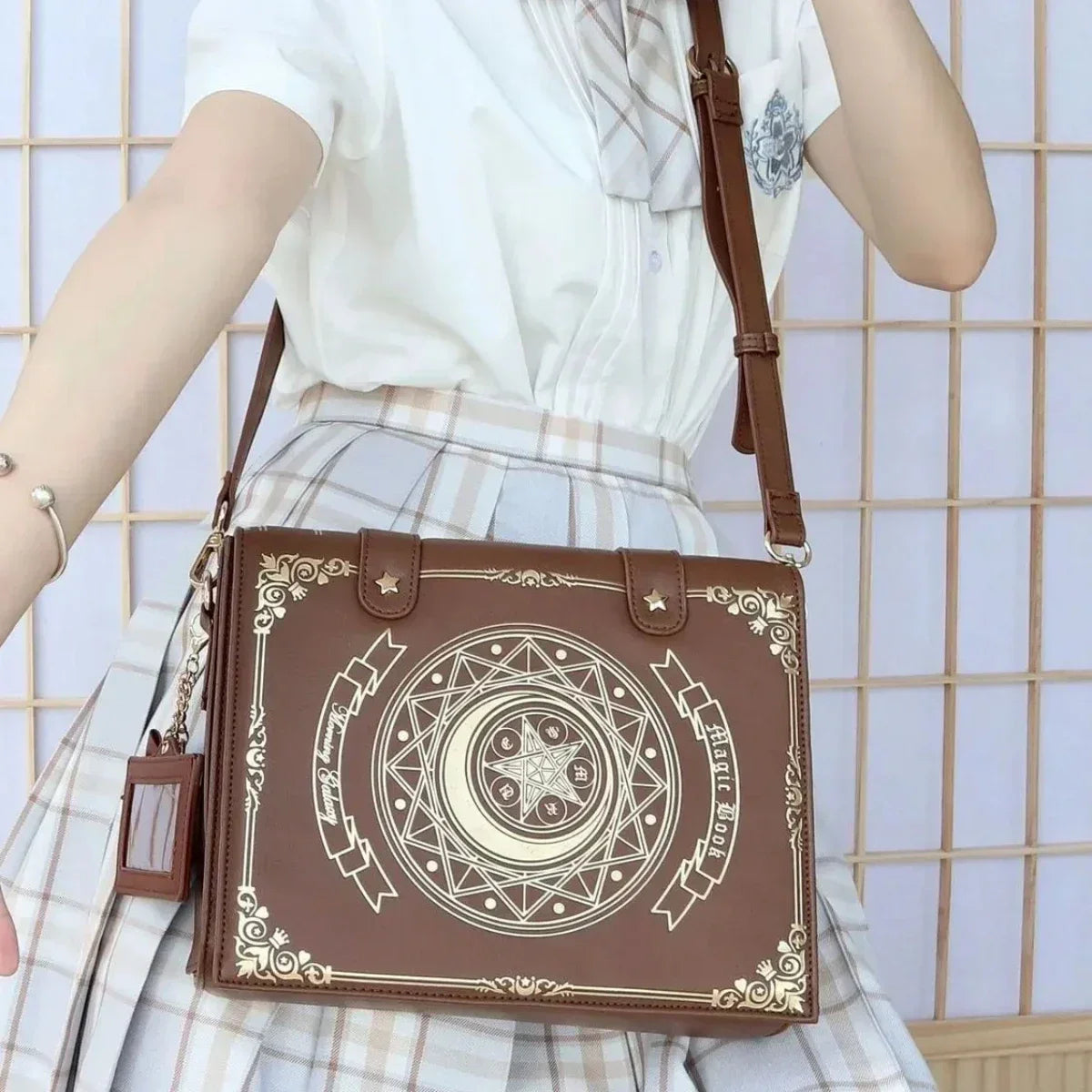 Brown spellbook shoulder bag with gold-tone celestial design