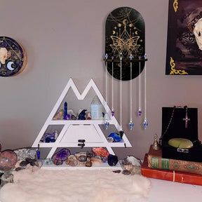 Moth wall shelf styled above a larger display shelf, with several pendants hanging from its notched ledge and crystals arranged around the room.