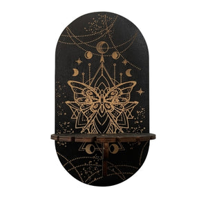 Black Butterfly display shelf with a gold-tone butterfly and geometric linework below hanging crescent and star motifs.