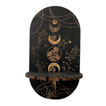 Black display shelf with a vertical sequence of botanical moon circles, gold-tone chain illustrations and a notched front ledge.
