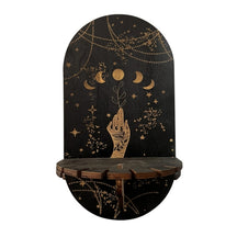 Moon Phases wooden shelf with an illustrated hand holding a leafy stem beneath gold-tone moons and hanging-chain artwork.