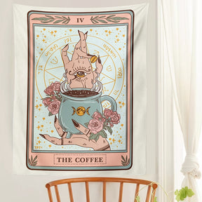 Coloured Coffee tapestry hung above a wooden chair, showing its pale background, pink border and central cup illustration.