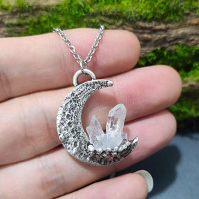 Silver crescent quartz moon pendant necklace with clear quartz crystals and textured finish on a delicate chain