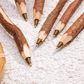 Close-up of ballpoint tips and textured branch-style pen barrels