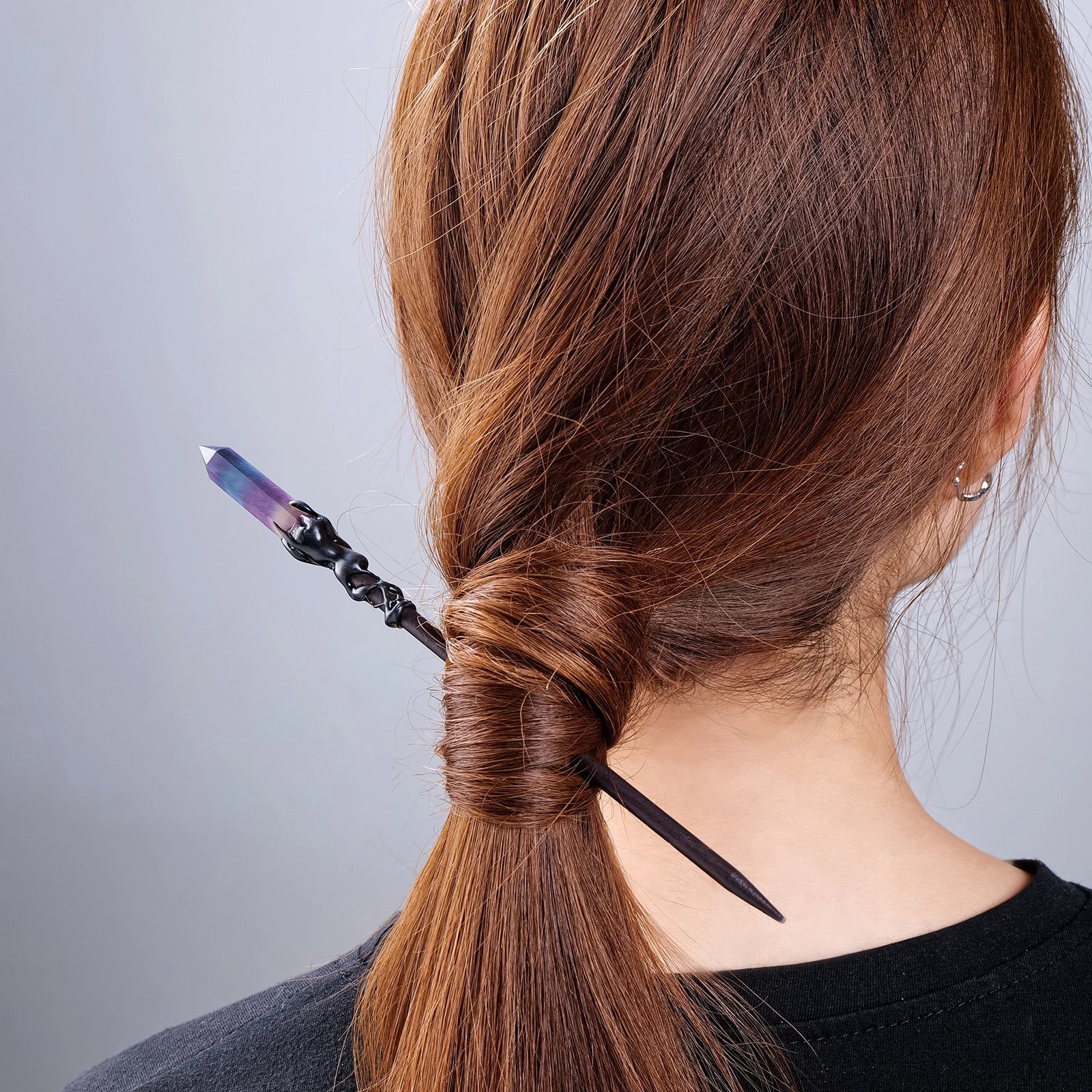 Pointed crystal hair stick worn diagonally through a twisted ponytail