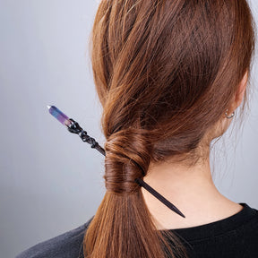Pointed crystal hair stick worn diagonally through a twisted ponytail
