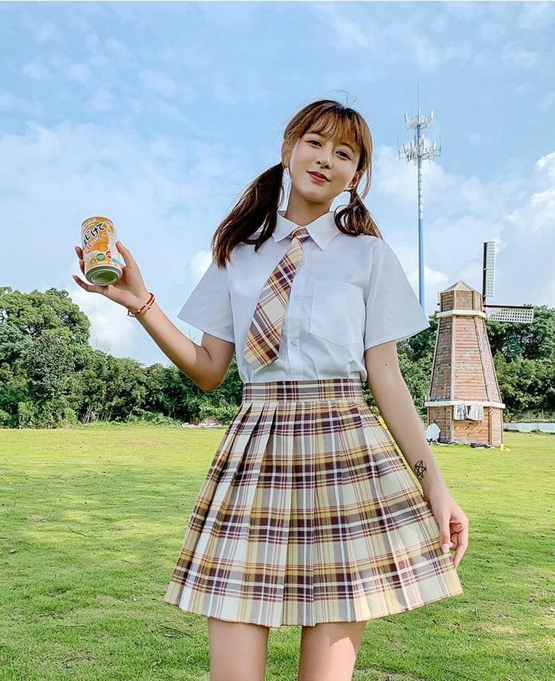 A girl wearing a white shirt and orange electric plaid skirt showing one of 17 color options for a school girl look