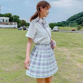 A light blue and white plaid skirt with pleats and a high waistband available in 17 color options perfect for school girl style