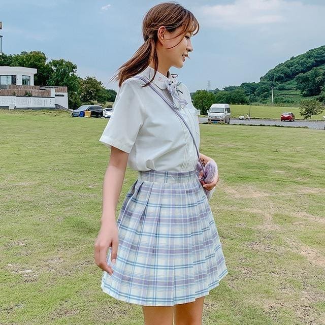 A light blue and white plaid skirt with pleats and a high waistband available in 17 color options perfect for school girl style