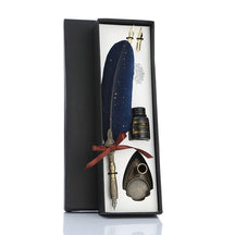 Blue feather dip pen gift set displayed in its fitted box with spare nibs, bottle and pen stand.