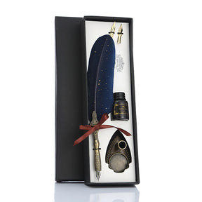 Blue feather dip pen gift set displayed in its fitted box with spare nibs, bottle and pen stand.