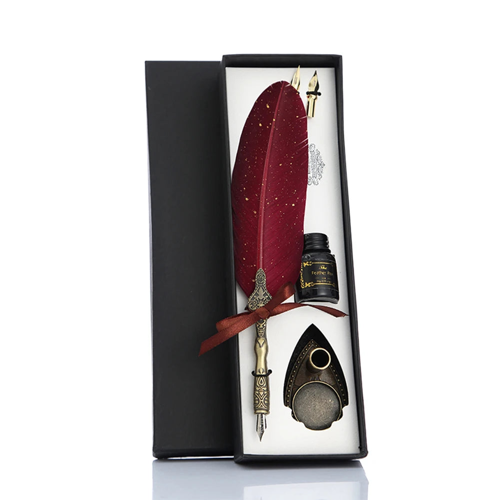 Red feather quill gift set in a fitted black box with spare nibs, a bottle and shield-shaped stand.