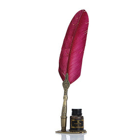 Red feather quill with gold-coloured speckles, an ornate handle and a small bottle beside the stand.
