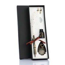White feather quill gift set in a fitted black box, showing the ribbon-tied pen, spare nibs, stand and bottle.