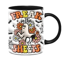 Additional view of the black-handled Freak in the Sheets mug, showing a central white ghost, flowers and bold curved lettering.