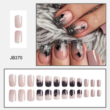Pink square false nails with dark glitter tips and black spiders, shown on hands and in a complete size layout.