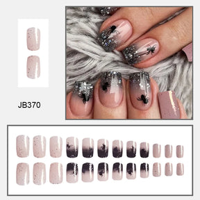 Pink square false nails with dark glitter tips and black spiders, shown on hands and in a complete size layout.