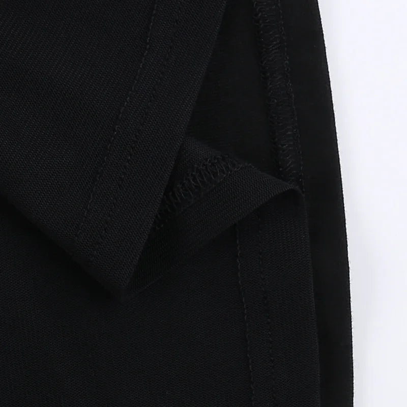 Inside lower edge of the black T-shirt, showing stitching where the mesh panel meets the hem.