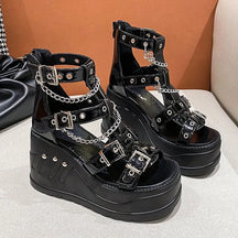 Pair of black gothic wedge sandals with glossy buckles and draped chains