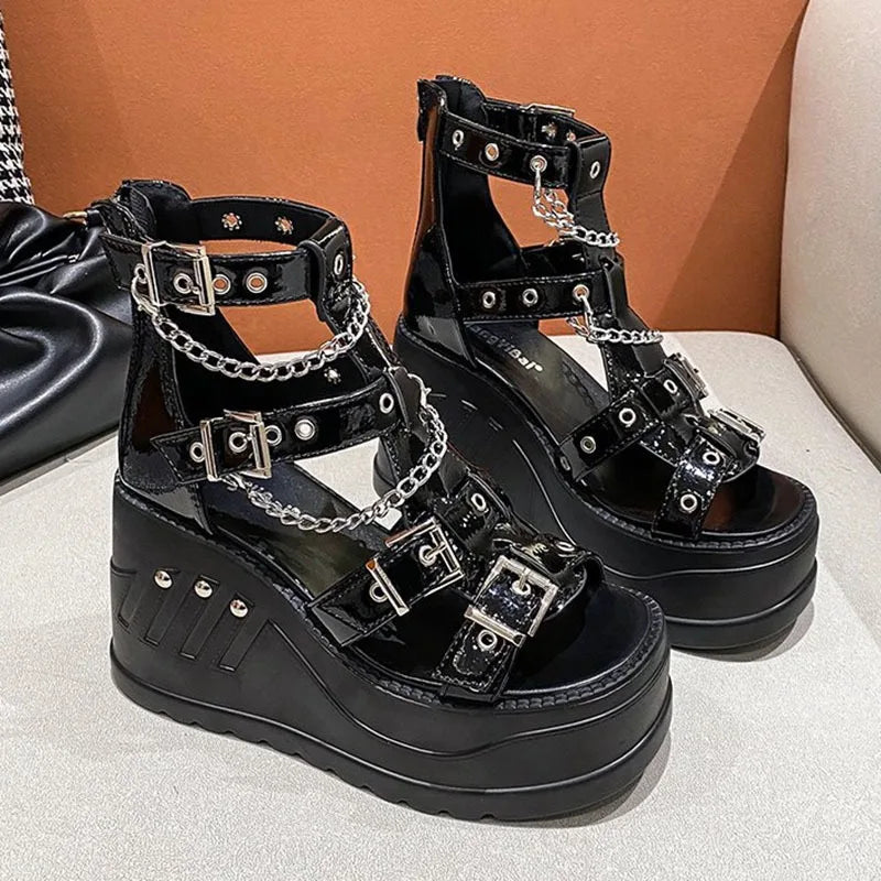 Pair of black gothic wedge sandals with glossy buckles and draped chains
