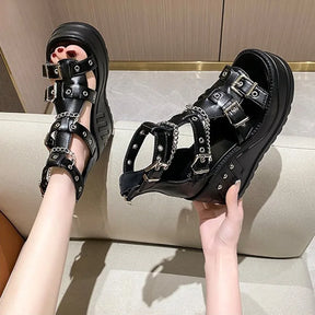 Hand-held black wedge sandal showing chain and buckle construction