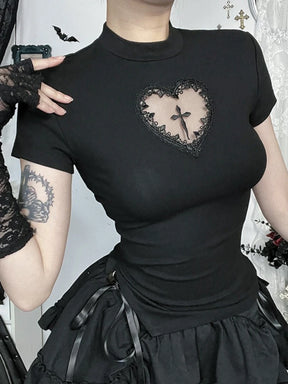 Portrait view of the black heart-cutout T-shirt with a hand near the shoulder, showing the lace border, central cross and short sleeves.