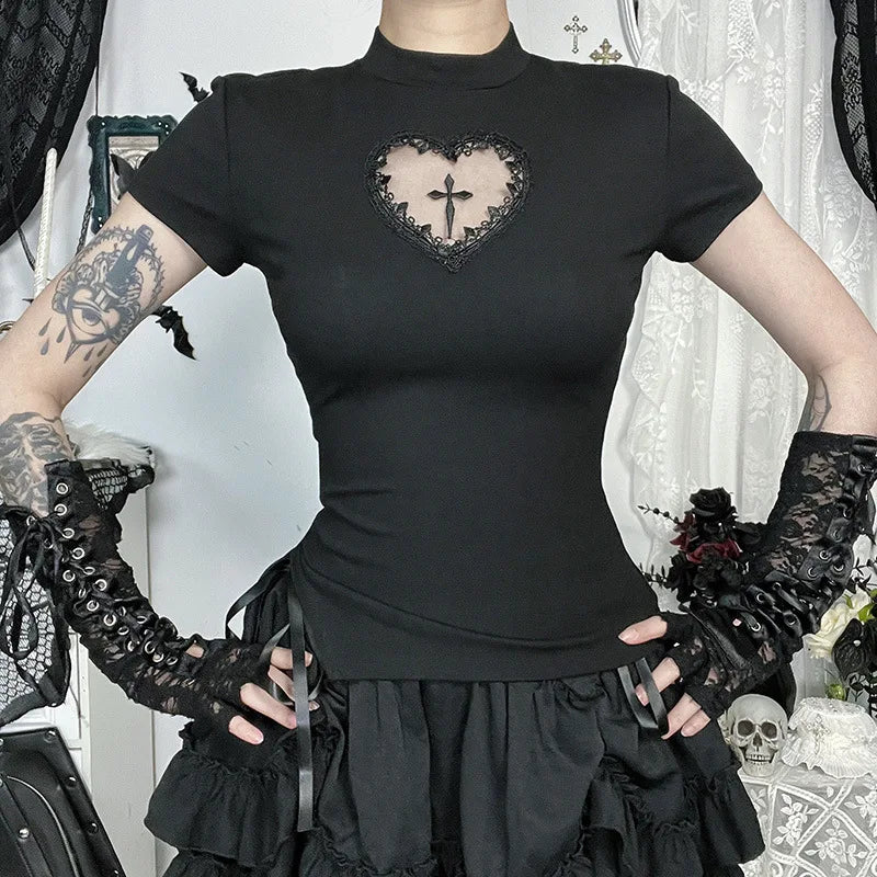 Black heart-cutout cross T-shirt shown with hands at the waist and a ruffled skirt, highlighting its slim shape.