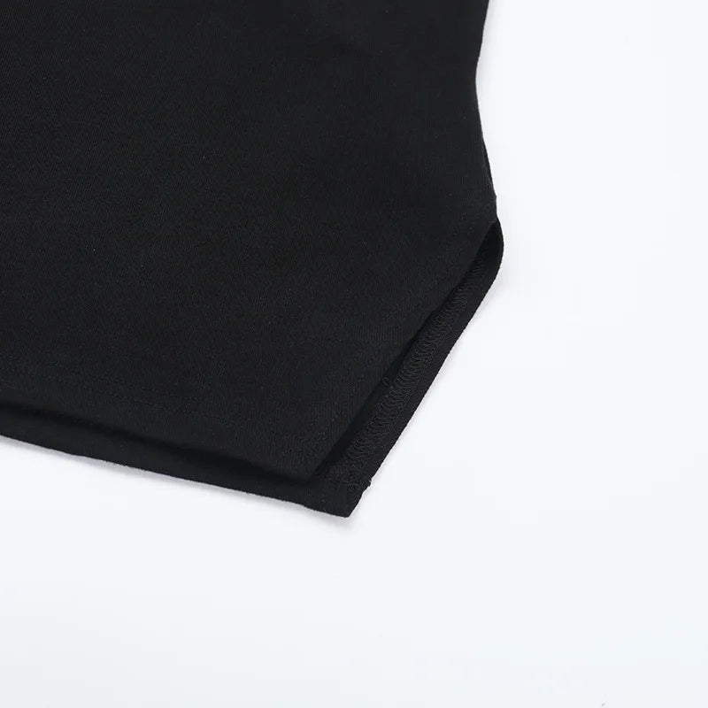 Lower corner of the black T-shirt laid flat, showing its shaped hem and stitched edge.