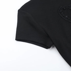 Close view of the black T-shirt's short sleeve, shoulder seam and part of the heart detail.