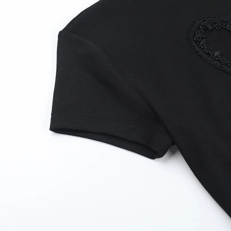 Close view of the black T-shirt's short sleeve, shoulder seam and part of the heart detail.