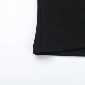 Close-up of the side seam and lower edge of the black fitted T-shirt.