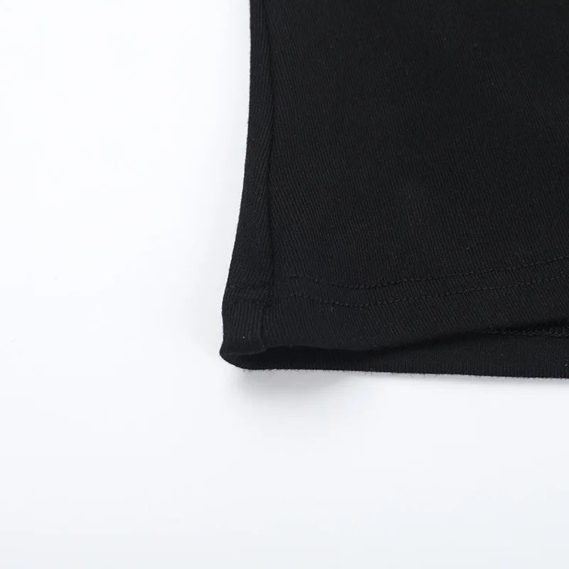 Close-up of the side seam and lower edge of the black fitted T-shirt.