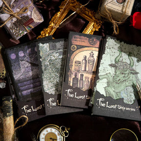 Four witchy stationery paper packs in purple, green, grey and amber tones, arranged beside ornate frames and a pocket watch.