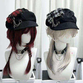 Red and monochrome plaid gothic newsboy caps displayed side by side with short brims, chains and cross charms.