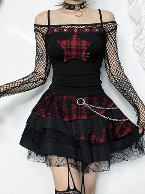 Front view of plaid star crop top styled with fishnet layers and a skirt