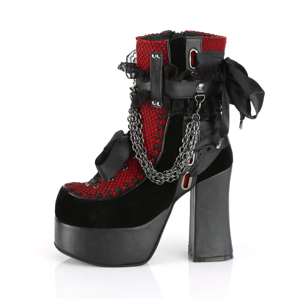 Angled view of a red lace platform ankle boot with black bows, hanging chains and a high block heel.