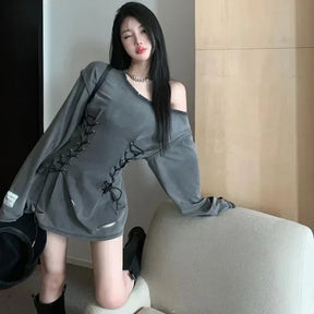 Gray corset-style mini dress styled with boots beside a chair