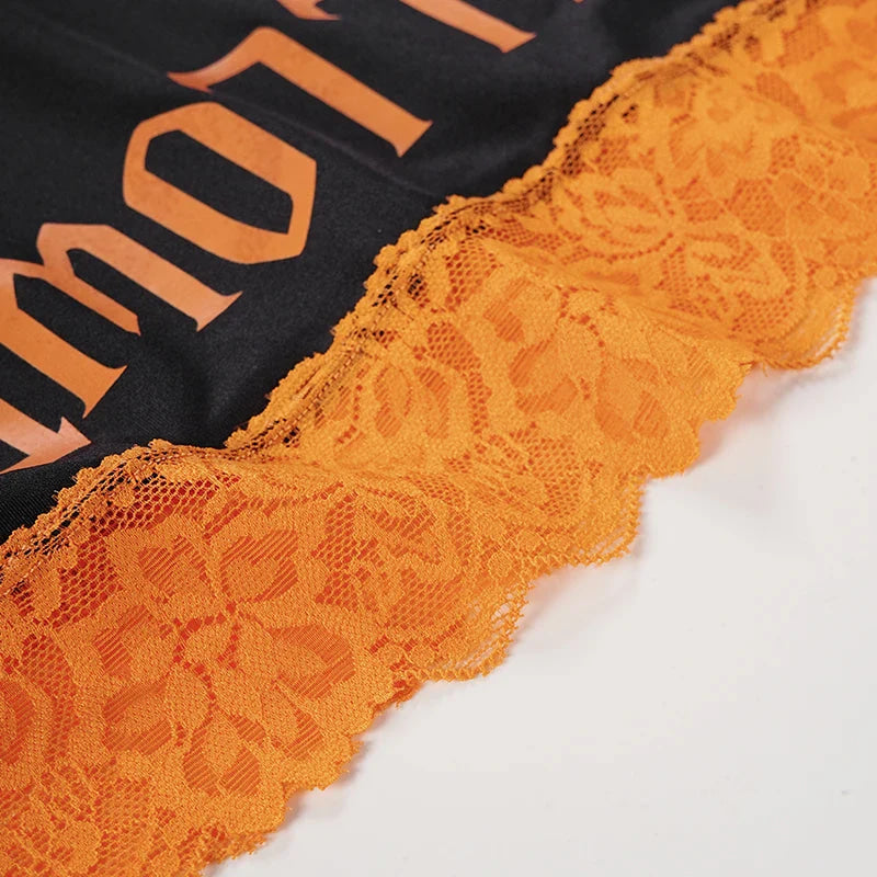 Close-up of the bright orange scalloped floral lace above Halloween lettering.