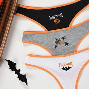 Black pumpkin, gray spider and white bat ribbed thongs arranged together, each with orange trim and front Halloween artwork.