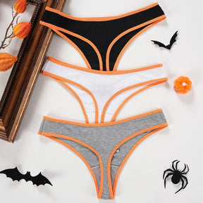Back views of black, white and gray Halloween thongs, showing their narrow thong cut and orange contrast binding.